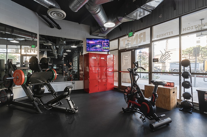 gym with stationary bicycles, squat rack, weights, and other gym equipment